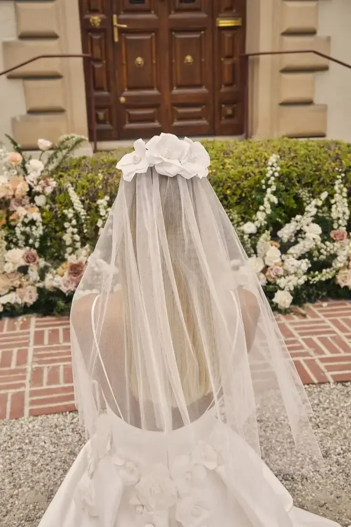 model is wearing a bridal gown with a short veil