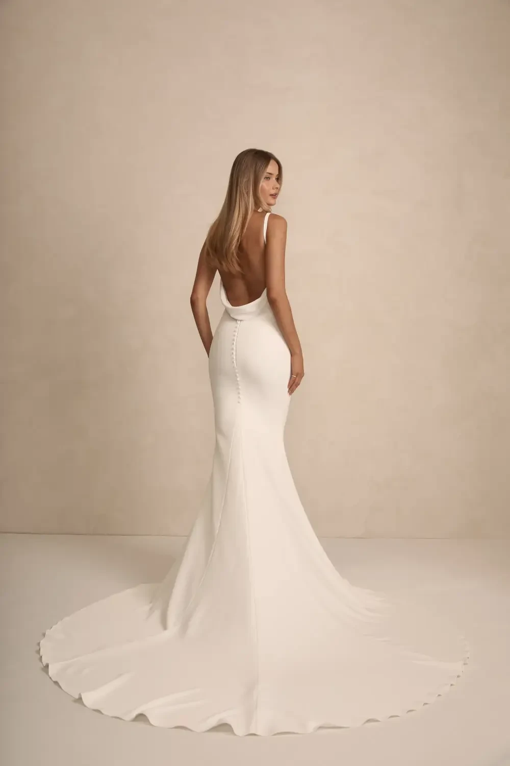 model is wearing a sleeveless sheath bridal gown
