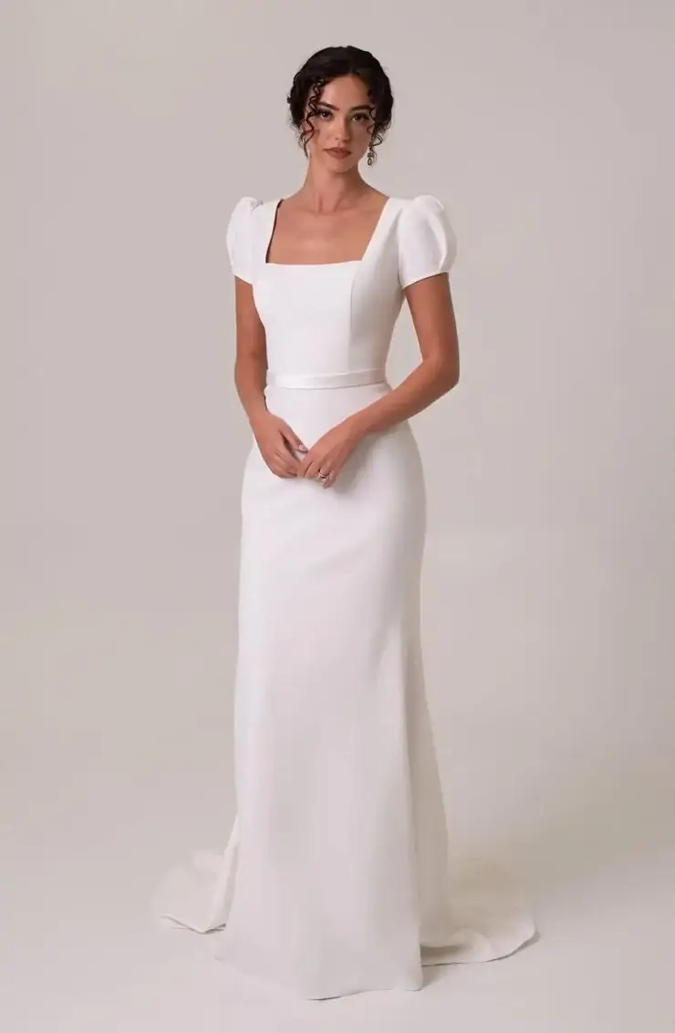 model is wearing a sheath wedding gown with short sleeves
